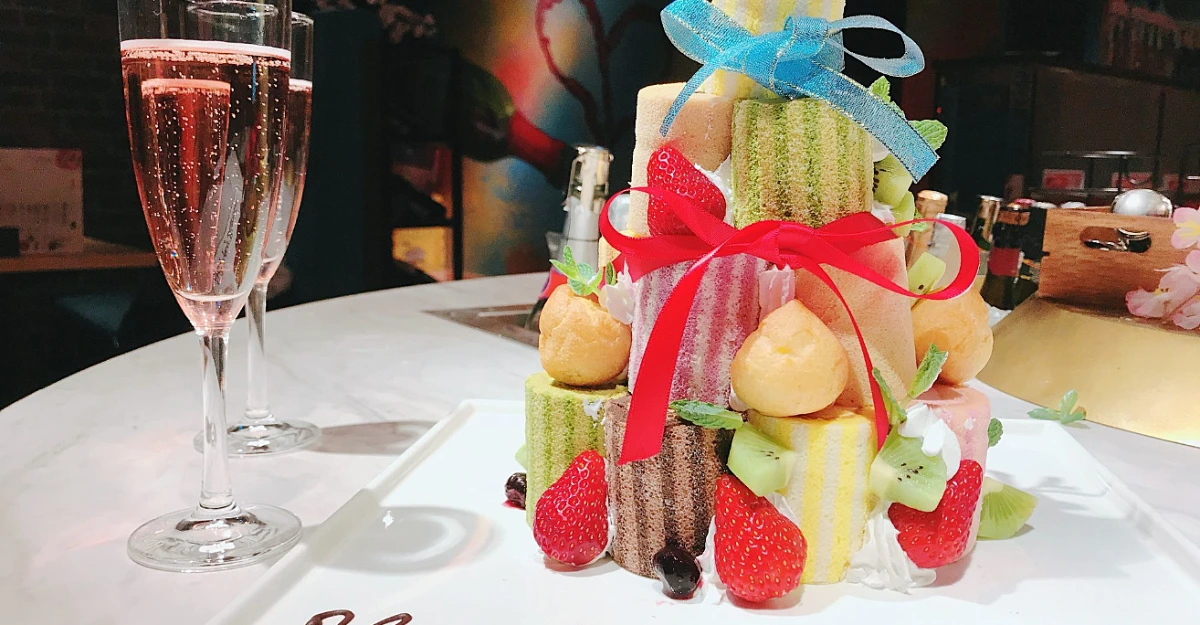 祝福の乾杯スパークリングとメッセージ付きロールケーキタワーで記念日を華やかに | 【メッセージ付きロールケーキタワー×アニバーサリープラン】ワインビュッフェ&豪華イタリアンディナー全8品★乾杯スパークリングつき★新宿で心温まるひとときを